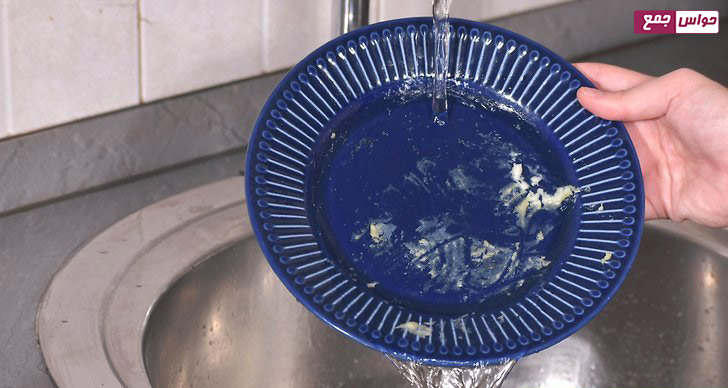 آبکشی ظرف‌ها برای قراردادن در ماشین ظرف شویی